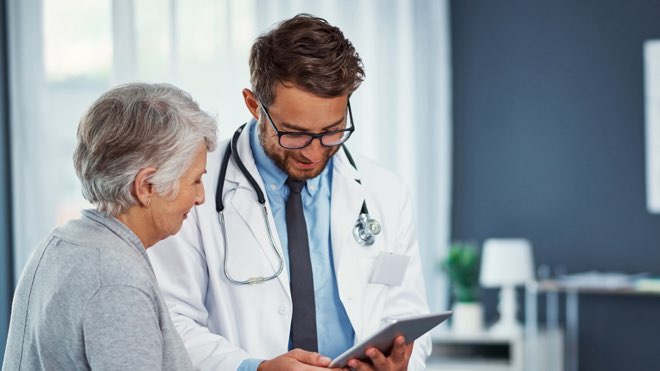 A doctor reading an SSCP document with a patient