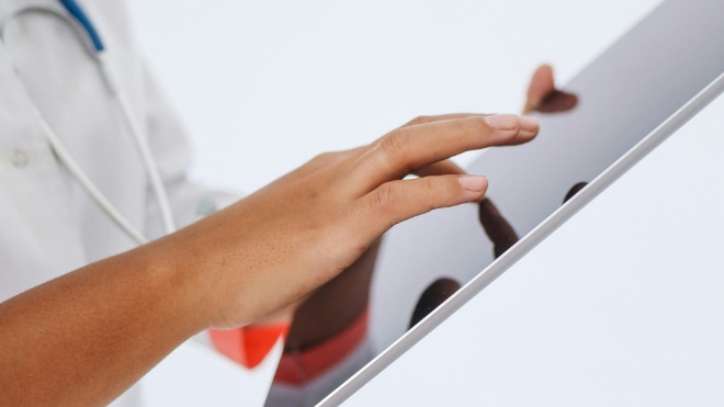 A doctor operates a tablet computer.